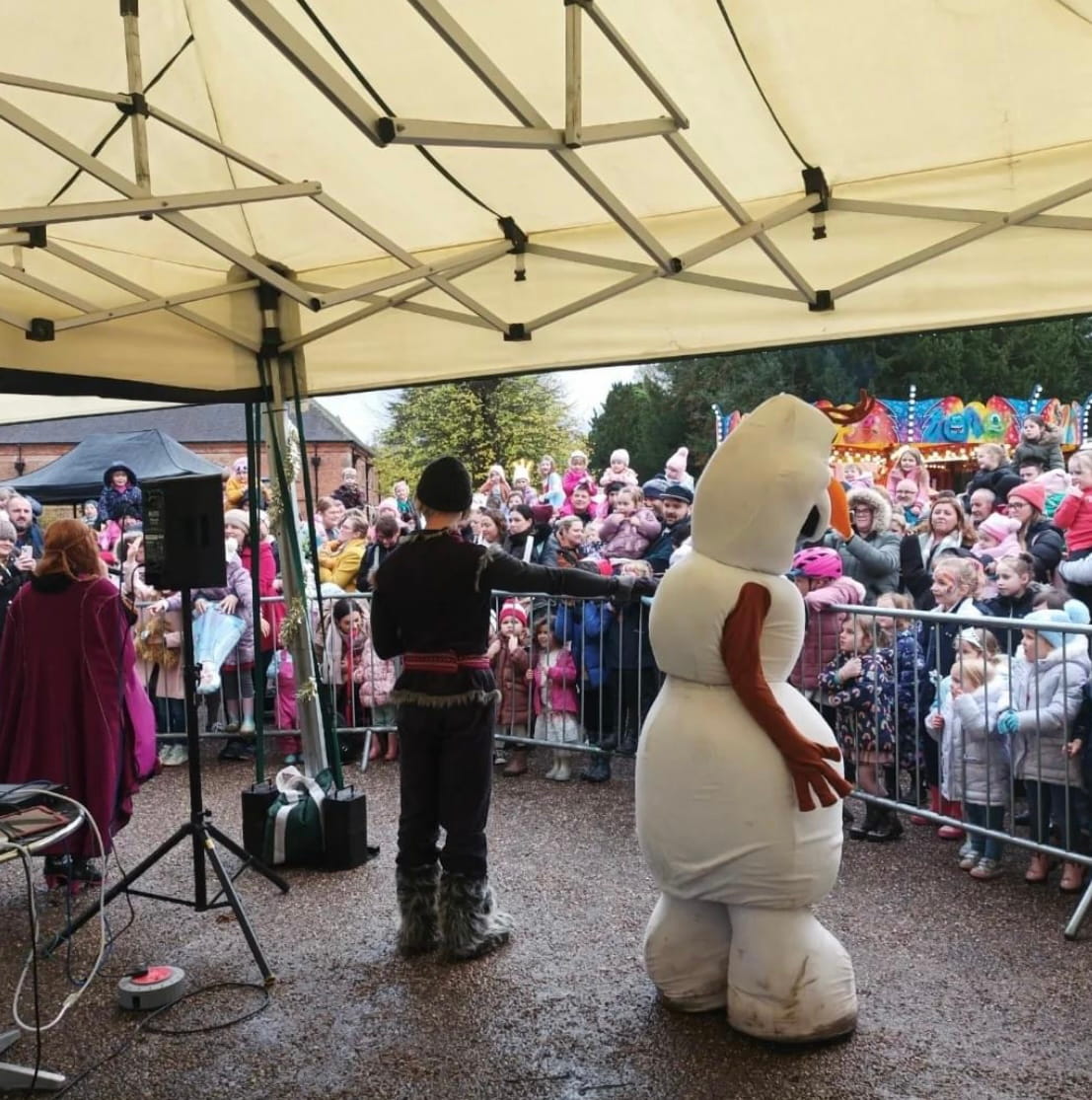 2 off 4m x 4m mini marquee gazebos at a Christmas event at Rufford, providing covered stage space for live entertainment with a large crowd of families