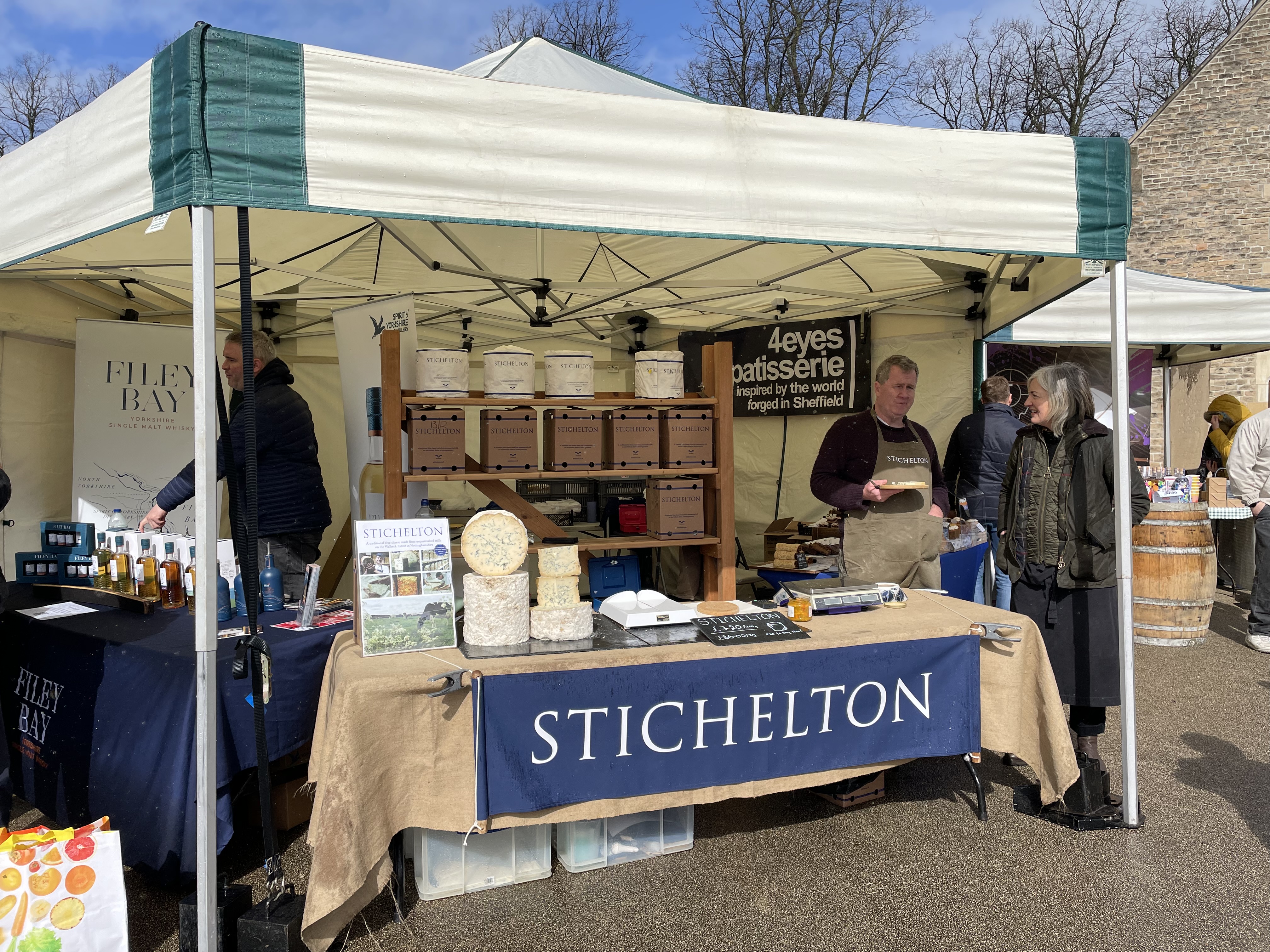 A 3m x 3m mini marquee gazebo providing covered vendor space at the Welbeck Easter Market, featuring a Stichelton cheese and artisan produce stall